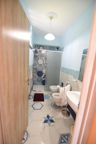 a bathroom with two toilets and a sink and a shower at La Casa Dei Desideri in Agerola