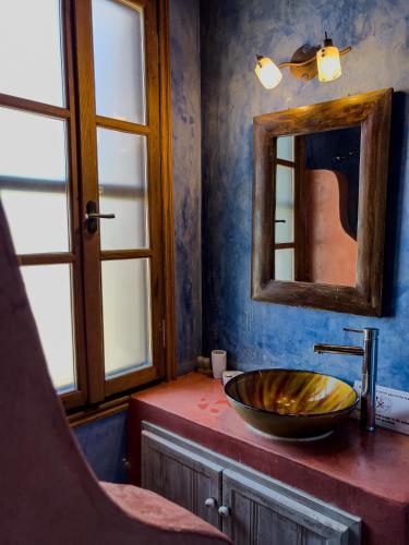 a bathroom with a bowl sink and a mirror at Agnanti Studios in Meyisti