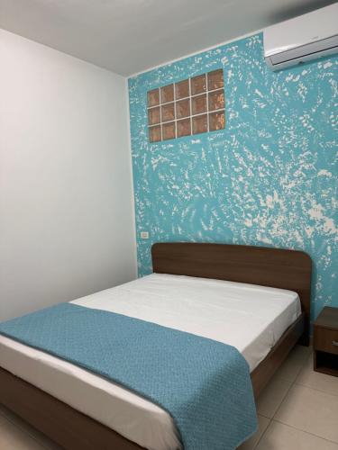 a bed in a room with a blue wall at Dimora Doria in Bari