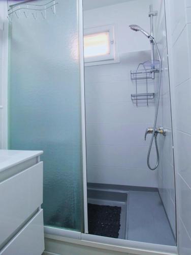 une douche avec une porte vitrée dans une salle de bain dans l'établissement Appartement Bord de mer, à Hyères