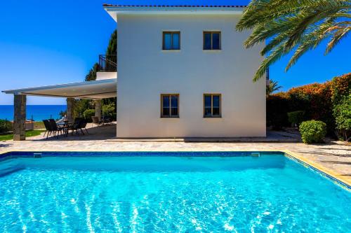 a villa with a swimming pool in front of a house at Argaka Sunset Villa in Argaka