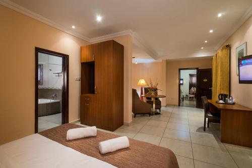 a hotel room with a bed and a bathroom at Midindi Hotel in Accra