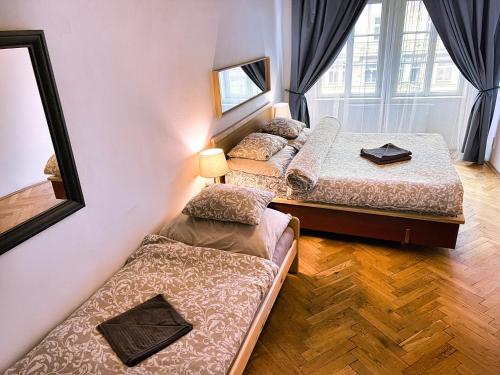 three beds in a room with a mirror at At the Blue Lion & Parking Assistance in Prague
