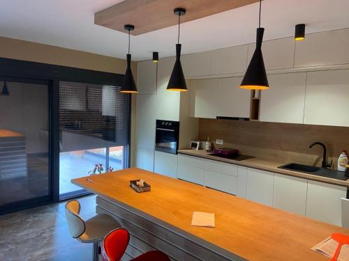 a kitchen with a wooden counter and some chairs at Vila Enesa in Dobra Voda