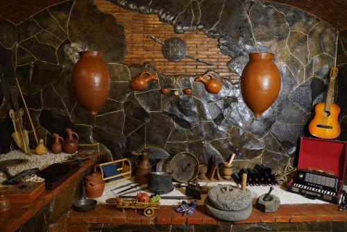 a room with a stone wall with vases on it at Hotel Hobbiton near Vardzia Caves in T'mogvi