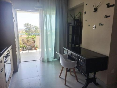 a desk with a chair in a room with a window at Sea View Floral Suite - Swimming pool- 2 bedroom in Larnaca