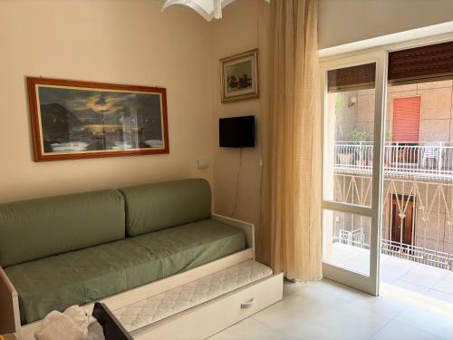 een woonkamer met een groene bank en een raam bij Casa Vacanza Gallipoli 1D in Gallipoli