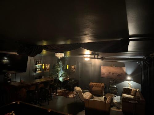 a dark living room with chairs and a table at Luxury 5 bedroom Wine Retreat Fallbrook Villa sleeps 12 in Fallbrook