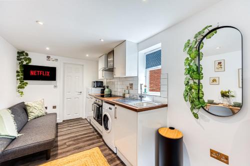 a kitchen and living room with a couch at Studio Flar near Luton Airport in Luton