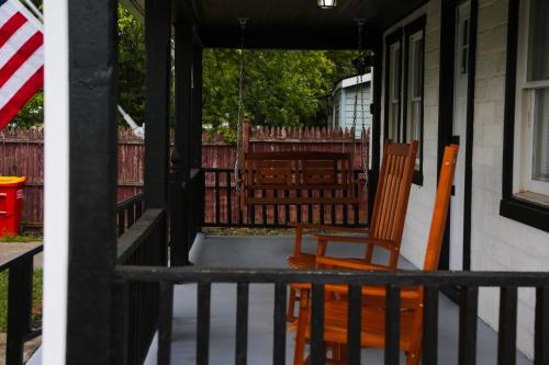 a porch with two chairs and a swing at 1939 Four Bed Rustic Escape by Casino in Ranson