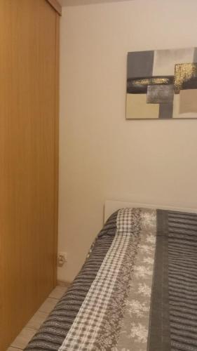 un lit dans une chambre avec un tableau sur le mur dans l'établissement Chambre privée, à Villenave-dʼOrnon