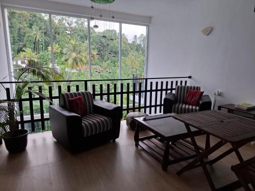 a living room with two chairs and a table at Aquahills in Kandy