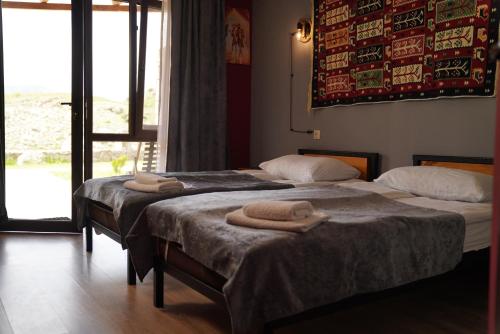 two beds in a room with towels on them at Hotel Hobbiton near Vardzia Caves in T'mogvi