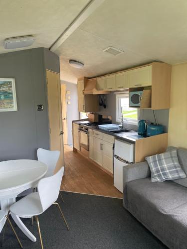 a kitchen and living room with a couch and a table at 95 Newquay bay Resort Dog friendly in Newquay