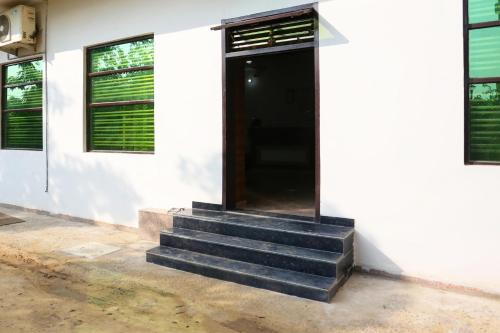 a door on the side of a white building with stairs at Hotel O Rajhans in Gurgaon