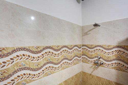 a bathroom with a shower with a tiled wall at Hotel O Rajhans in Gurgaon