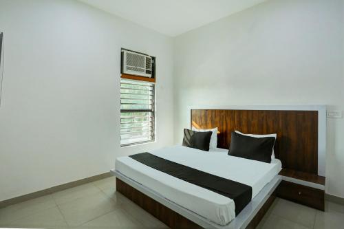 a bedroom with a large bed and a window at Hotel O Rajhans in Gurgaon