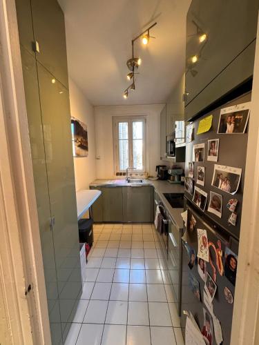 une petite cuisine avec un évier et un comptoir dans l'établissement Superbe appartement Haussmanien à 4min de St Lazare et la Défense, à Asnières-sur-Seine