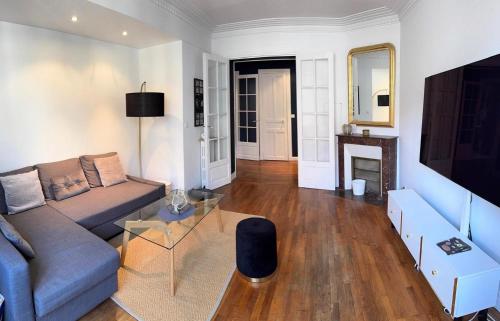 un salon avec un canapé et une table dans l'établissement Superbe appartement Haussmanien à 4min de St Lazare et la Défense, à Asnières-sur-Seine