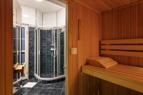 a sauna with a shower and a bench in a room at FAMILIJNY Ośrodek Wypoczynkowy Krynica Zdrój in Krynica Zdrój