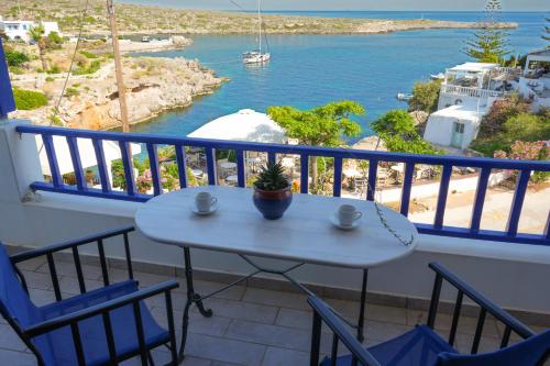 a table and chairs on a balcony with a view of the water at Varda apartments - Kythoikies holiday houses in Kýthira