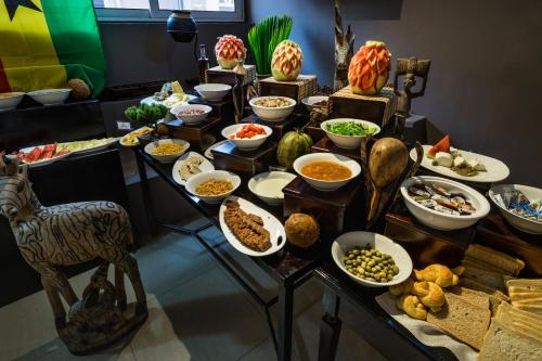 a buffet with different types of food on a table at Midindi Hotel in Accra