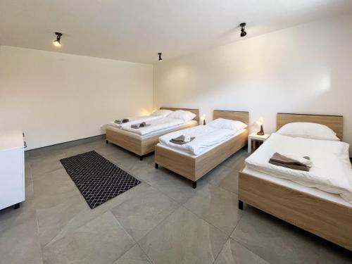 a room with two beds and two tables at Rodinný Apartmán s 2 Spálňami in Veľká Lomnica