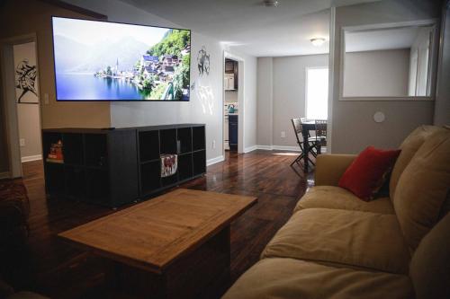 a living room with a couch and a flat screen tv at 1939 Four Bed Rustic Escape by Casino in Ranson