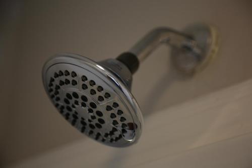 a shower head with a faucet in a bathroom at 1939 Four Bed Rustic Escape by Casino in Ranson