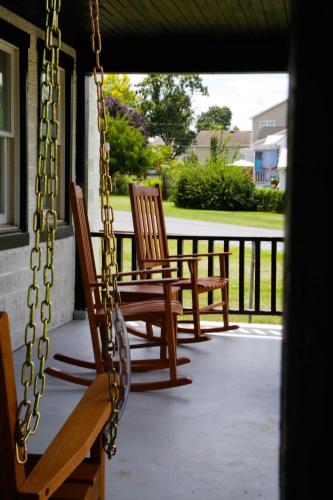 two chairs and a swing on a porch at 1939 Four Bed Rustic Escape by Casino in Ranson