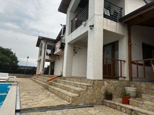 a house with a swimming pool in front of it at Pensiunea Maria Agighiol in Agighiol