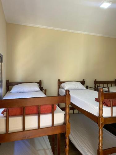 a group of three beds in a room at Hostel Fratelli Costa in Delfinópolis
