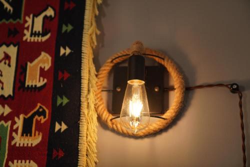 a light with a wreath on a wall at Hotel Hobbiton near Vardzia Caves in T'mogvi