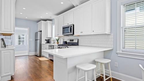 Modern Coastal Comfort - 3 Bedroom Condo with Balcony في أوشن سيتي: مطبخ بدولاب بيضاء وقمة بيضاء