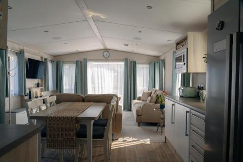 a kitchen and a living room with a table in a caravan at New Forest Retreat on a Holiday Park in New Milton