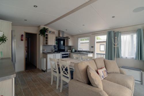 a living room and kitchen with a couch and a table at New Forest Retreat on a Holiday Park in New Milton