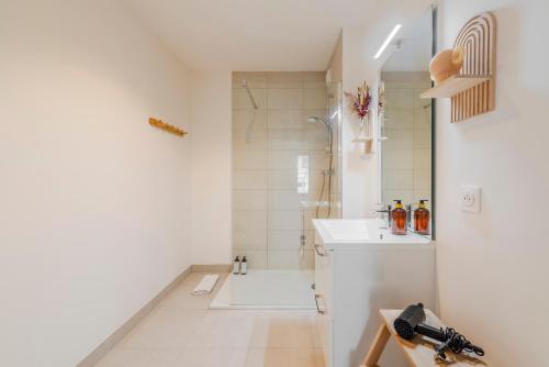 a white bathroom with a shower and a sink at Appartement familial 5 min Disney 30 min Paris in Montévrain