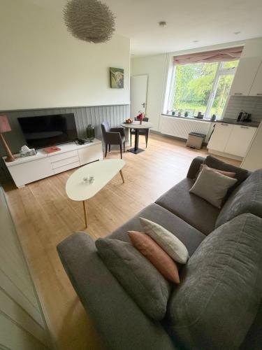 a living room with a couch and a table at Nisterlo Guesthouse in Nistelrode