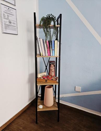 a book shelf with books and a plant on it at Studio in the heart of Paphos in Paphos