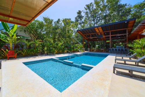 a swimming pool with two chairs and a house at Paradise Studio- Pool, beach, yoga in Talamanca