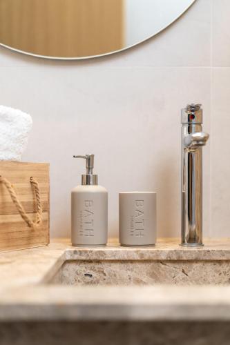 a bathroom sink with two soap dispensers on a counter at Sunset Apartment in Ierapetra