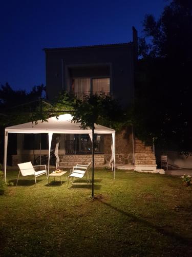 a white gazebo in the yard of a house at Alex house in Kouramaditika