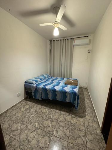 a bedroom with a bed and a ceiling fan at Casa Duplex Temporada in Guarapari
