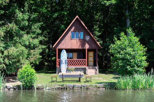 a small house with a surfboard in front of it at FOREST, lake, FIREFLIES, campfire - WHAT ELSE in Jindrichuv Hradec