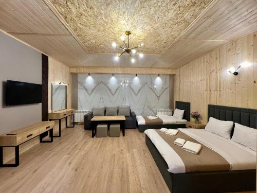 a room with two beds and a couch and a tv at Milenium magic villas on Sevan beach in Sevan