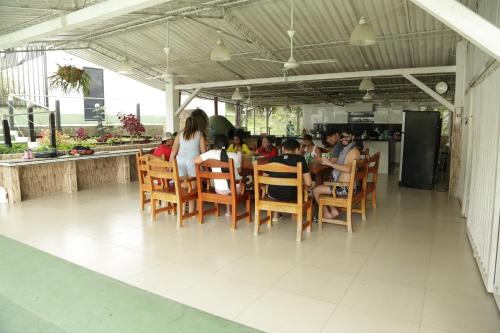 un grupo de personas sentadas en una mesa en un restaurante en FINCA SAN JAVIER GREAT FARM WITH HORSES AND POOl, en Sasaima