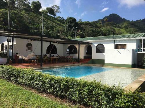 una casa con piscina en el patio en FINCA SAN JAVIER GREAT FARM WITH HORSES AND POOl, en Sasaima