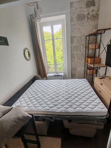 un lit assis dans une pièce avec une fenêtre dans l'établissement Cosy Mezzanine Studio - Nice Notre Dame - 10 min Promenade, à Nice