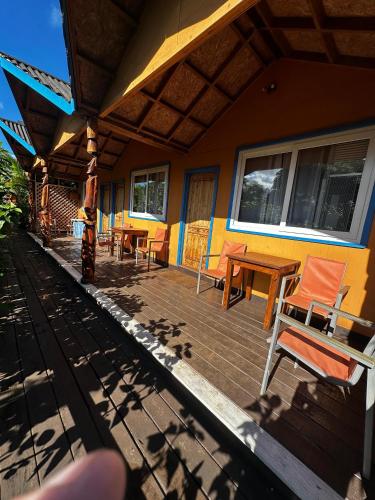 a porch of a house with chairs and tables at Hare Village in Hanga Roa