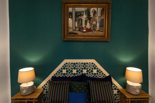 a bedroom with a bed with a picture on the wall at BDar Stay Maison d'hôtes avec piscine et rooftop à Tozeur, à 10 min de la Médina in Tozeur